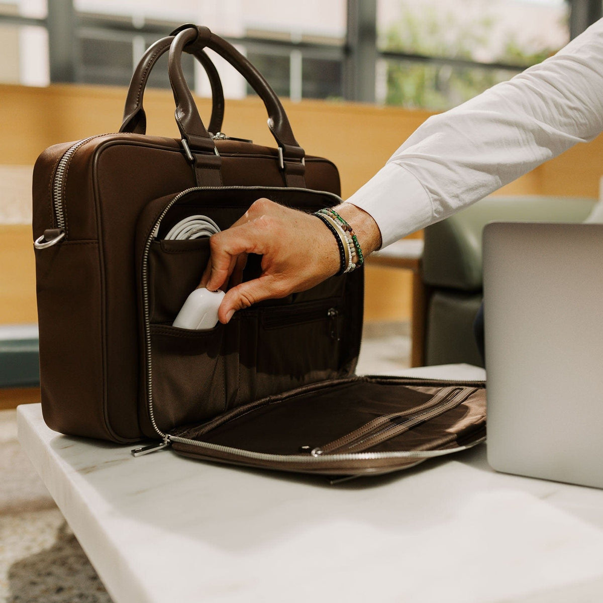 A hand reaching into the brown Alto's front organiser on a desk